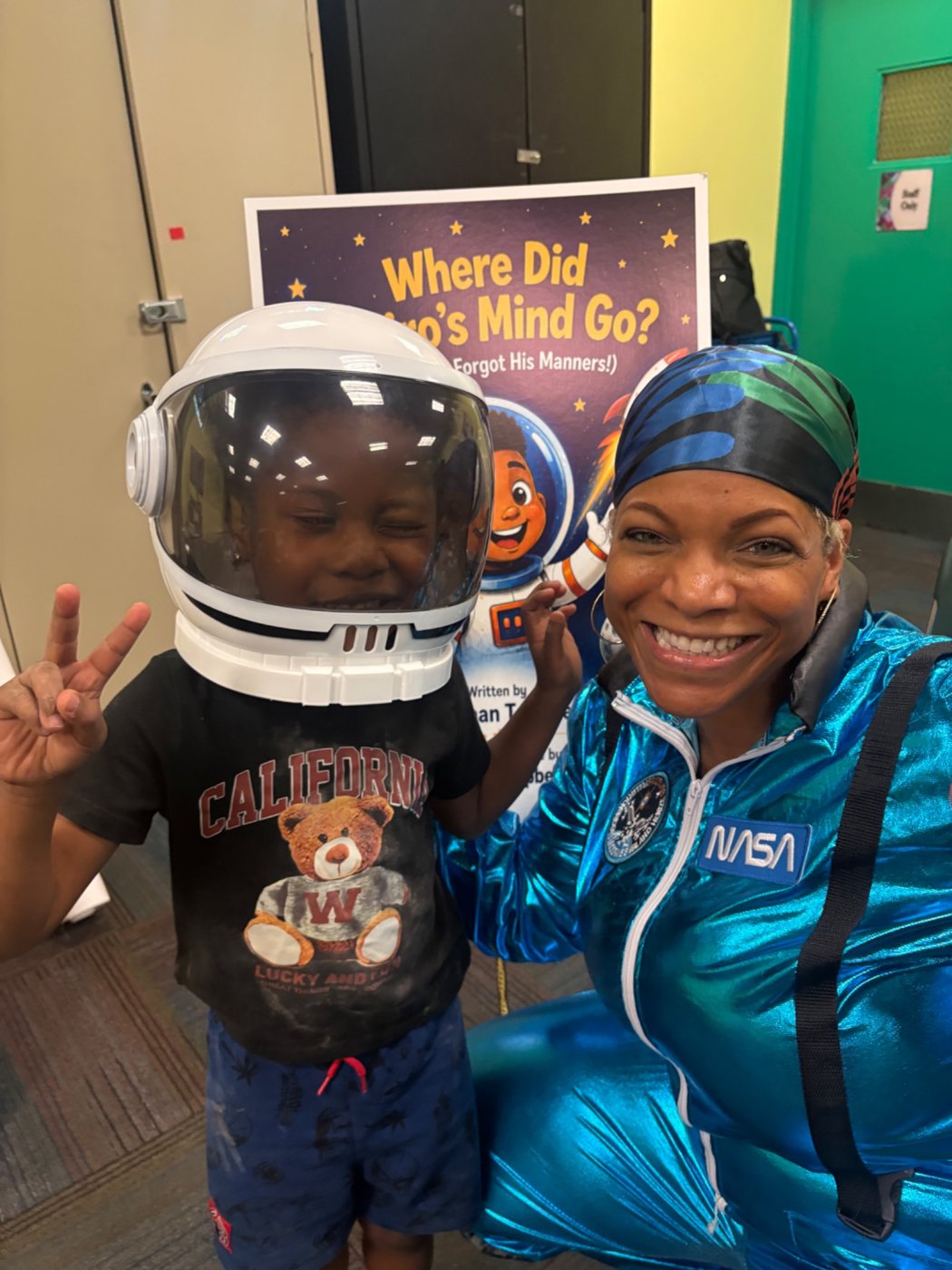 Captain Keishan with a young participant wearing the space helmet at Laurelton Library